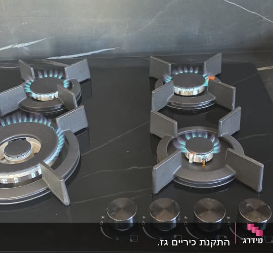 כיריים גז זכוכית שחורה של סאוטר מותקנות ודולקות על שיש מטבח